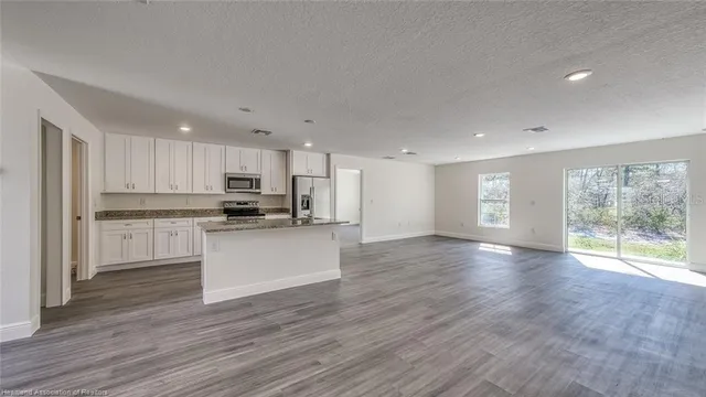 a view of kitchen with wooden floor and electronic appliances