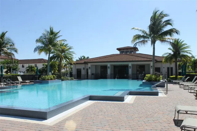 a front view of a house with a garden and lake view