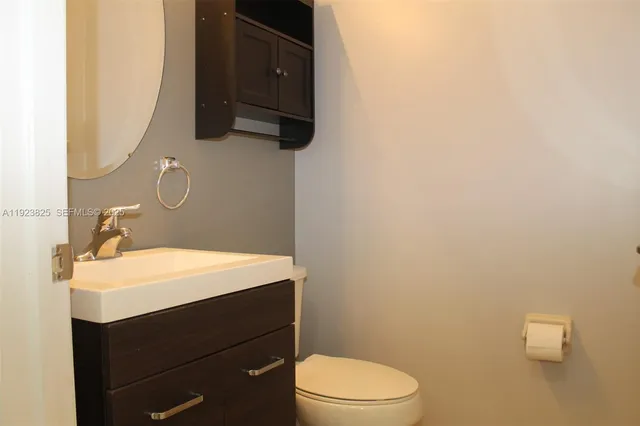 a bathroom with a sink a toilet and mirror