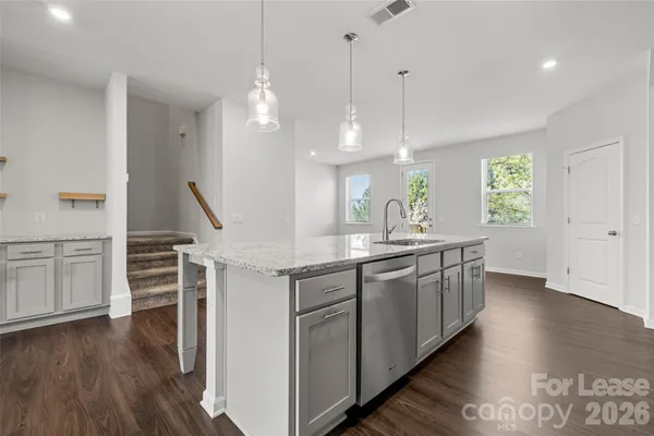 a large kitchen with kitchen island white cabinets and wooden floor