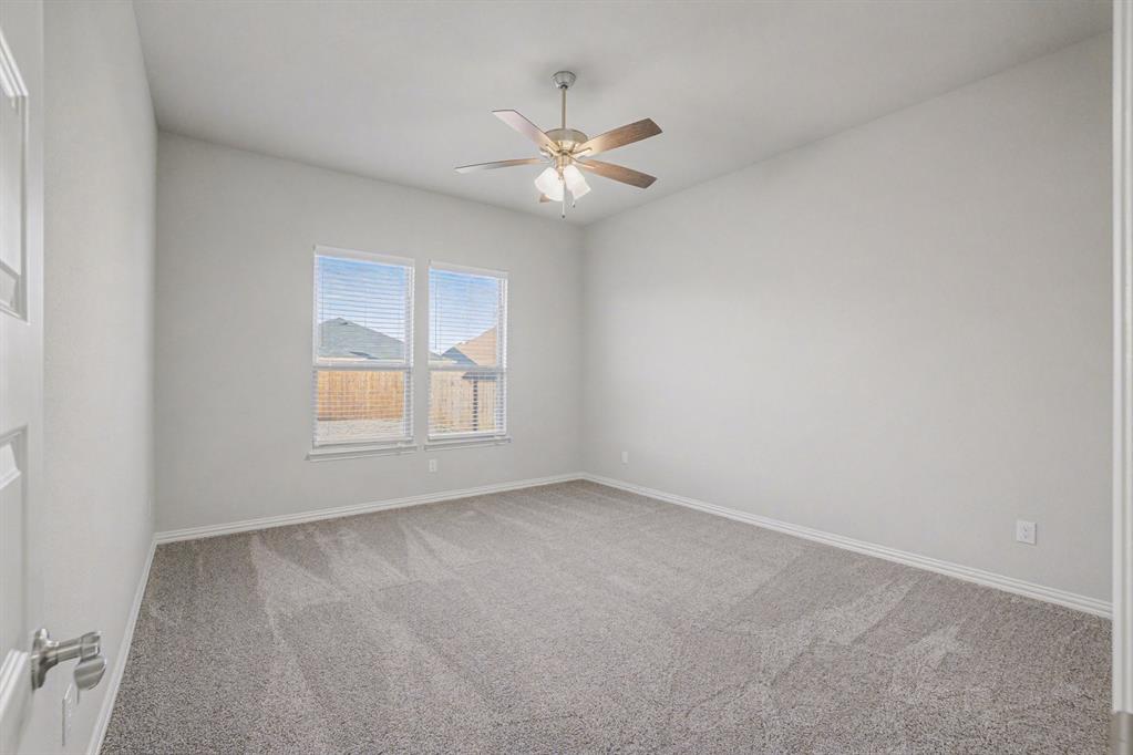 2404 Peebles Lane Denton, TX 76207 - Photo 14 of 30 an empty room with windows and fan