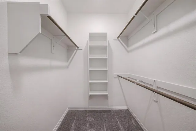 a view of walk in closet with empty racks