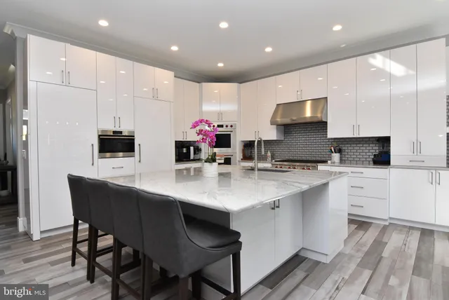 a kitchen with stainless steel appliances a sink table and chairs