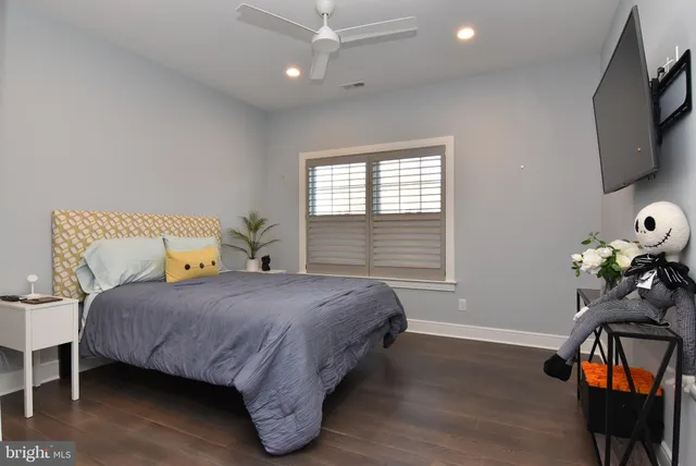 a bedroom with a bed table closet and a window