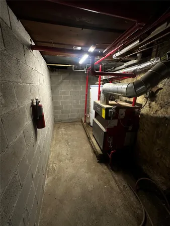 a room with water heater and wooden cabinets