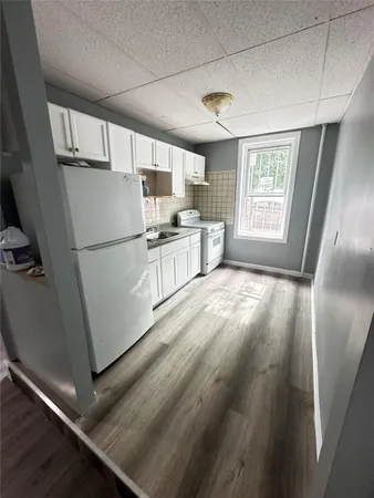 a kitchen with a refrigerator a stove top oven a sink and a window