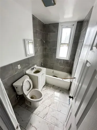 a bathroom with a toilet sink and mirror