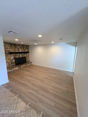 an empty room with wooden floor and a hallway
