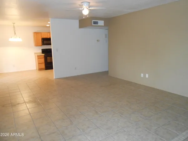 an empty room with kitchen and chandelier