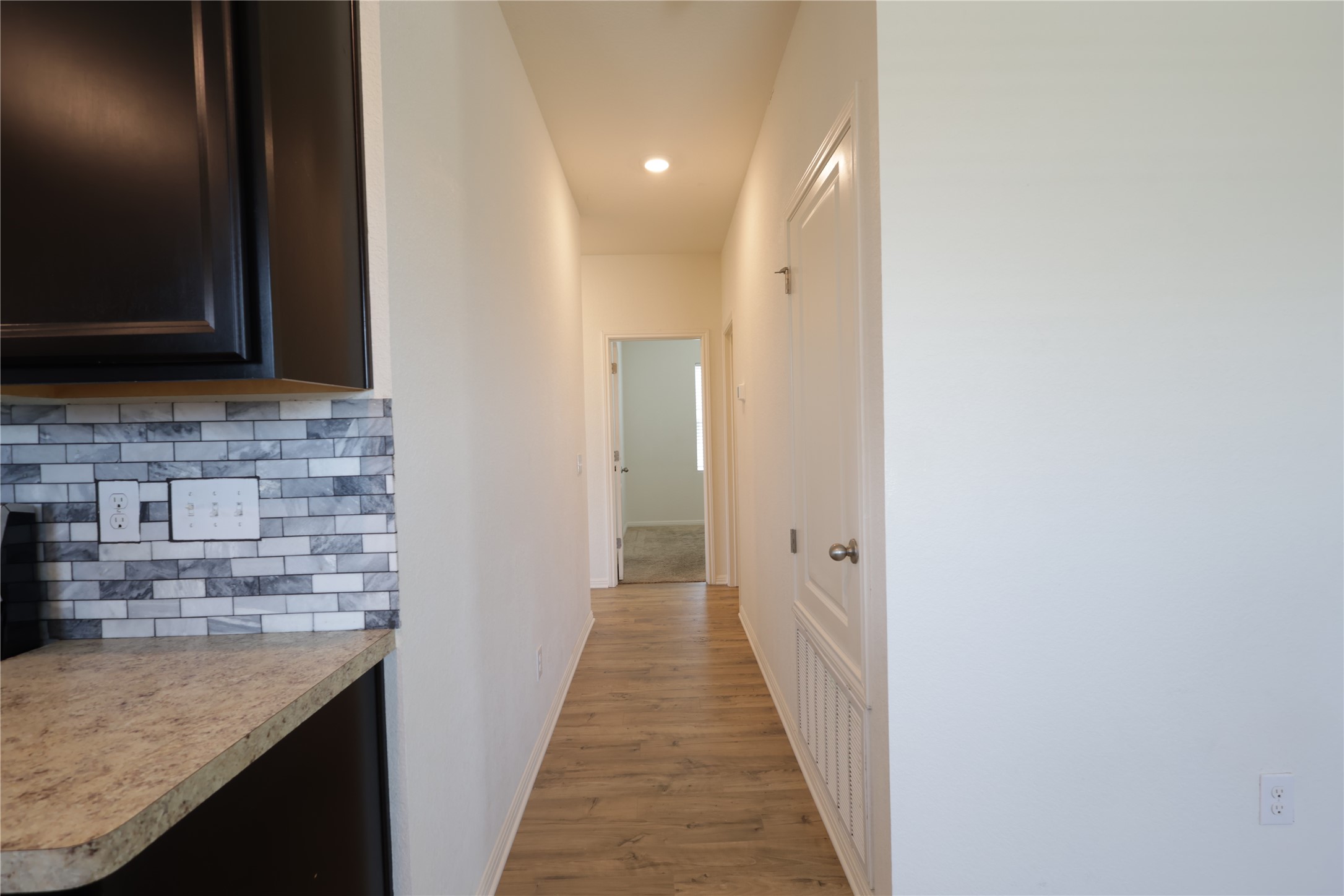 250 Seneca Loop Kyle, TX 78640 - Photo 6 of 22 Clean lines define this versatile hallway with durable flooring leading to additional living spaces.