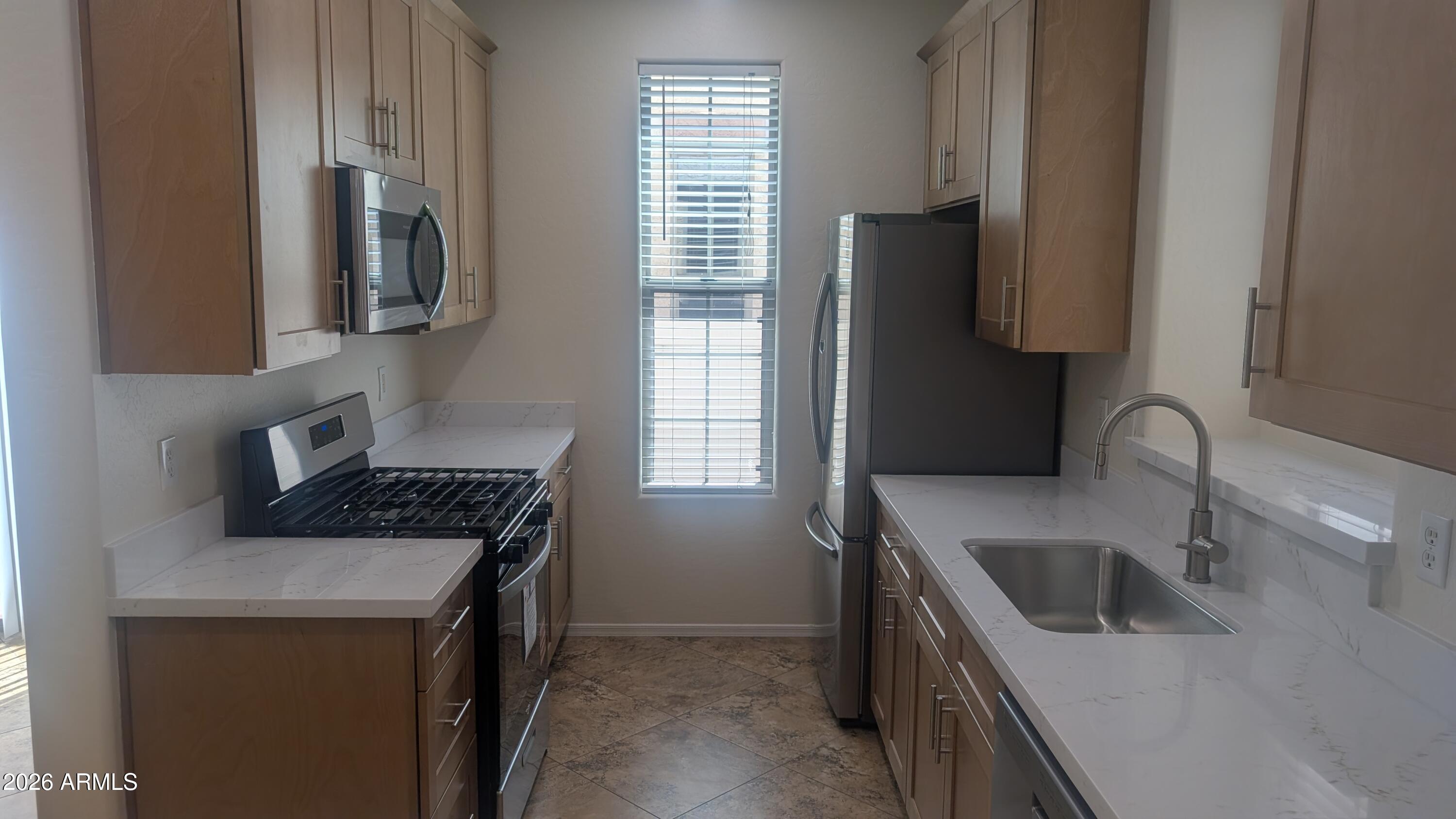 1453 South Sinova Avenue Gilbert, AZ 85296 - Photo 9 of 46 a kitchen that has a sink and a stove