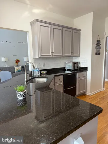 a kitchen with granite countertop white cabinets and white appliances