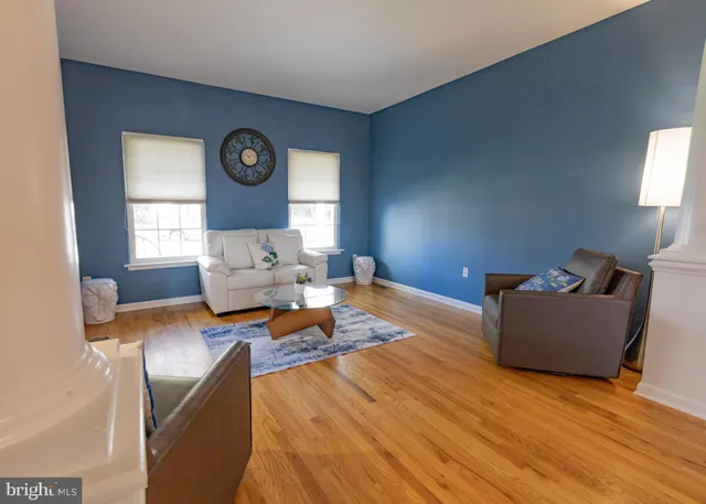 a dining room with furniture a chandelier and wooden floor
