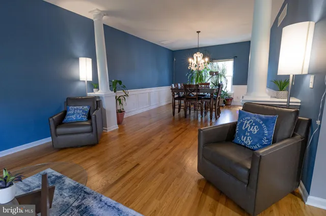 a kitchen with stainless steel appliances granite countertop a stove top oven a sink dishwasher a refrigerator and a dining table with wooden floor