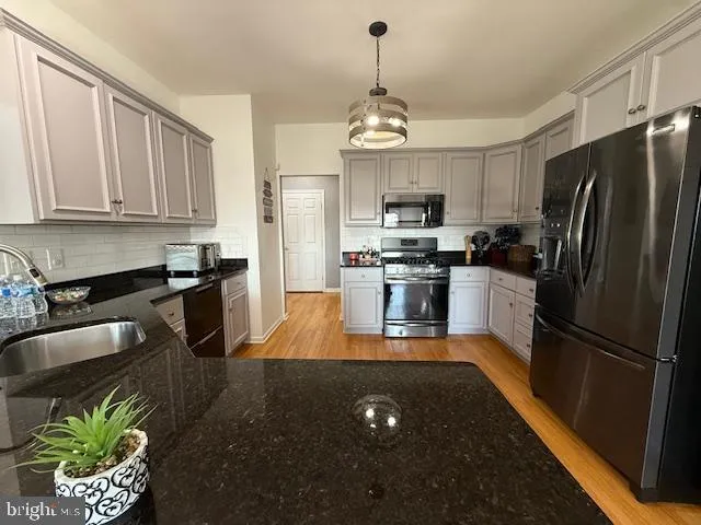 a kitchen with stainless steel appliances granite countertop a stove a microwave and a refrigerator