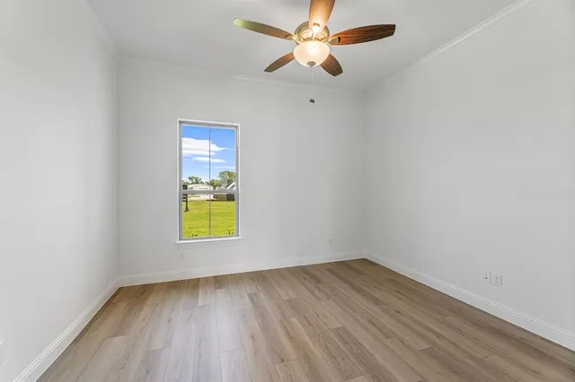 an empty room with a window and wooden floor