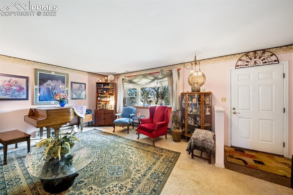 9180 McClelland Road Calhan, CO 80808 - Photo 17 of 31 a living room with furniture and a chandelier
