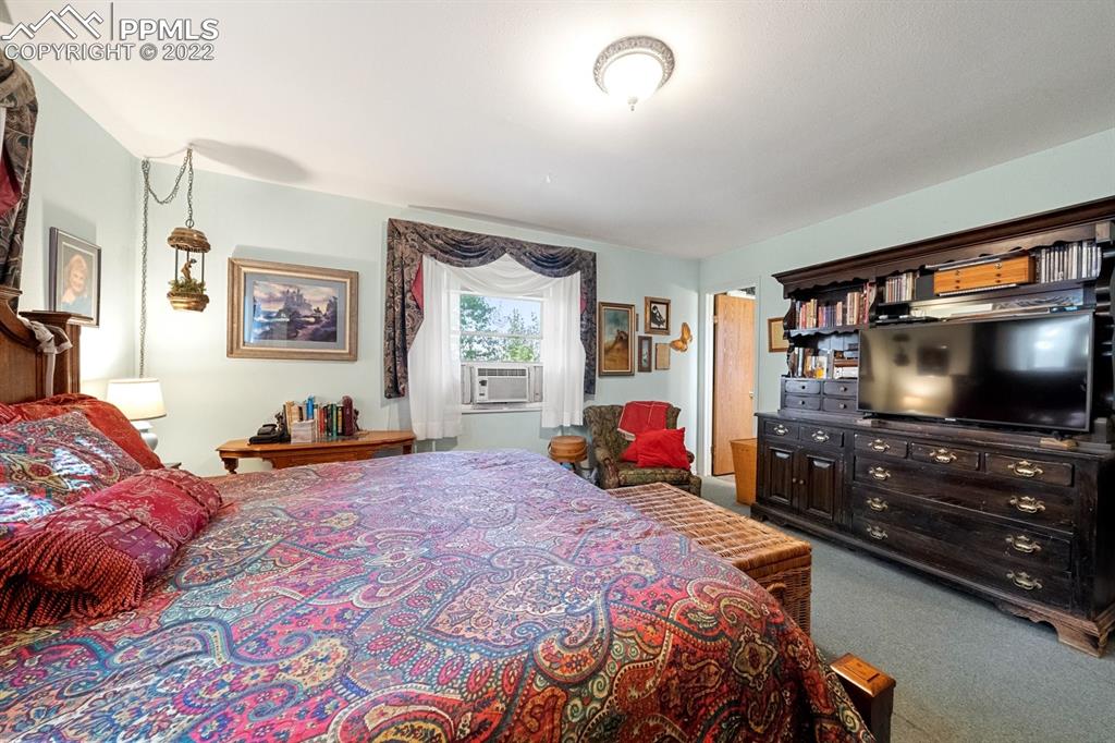 9180 McClelland Road Calhan, CO 80808 - Photo 22 of 31 a bedroom with a bed and a flat screen tv