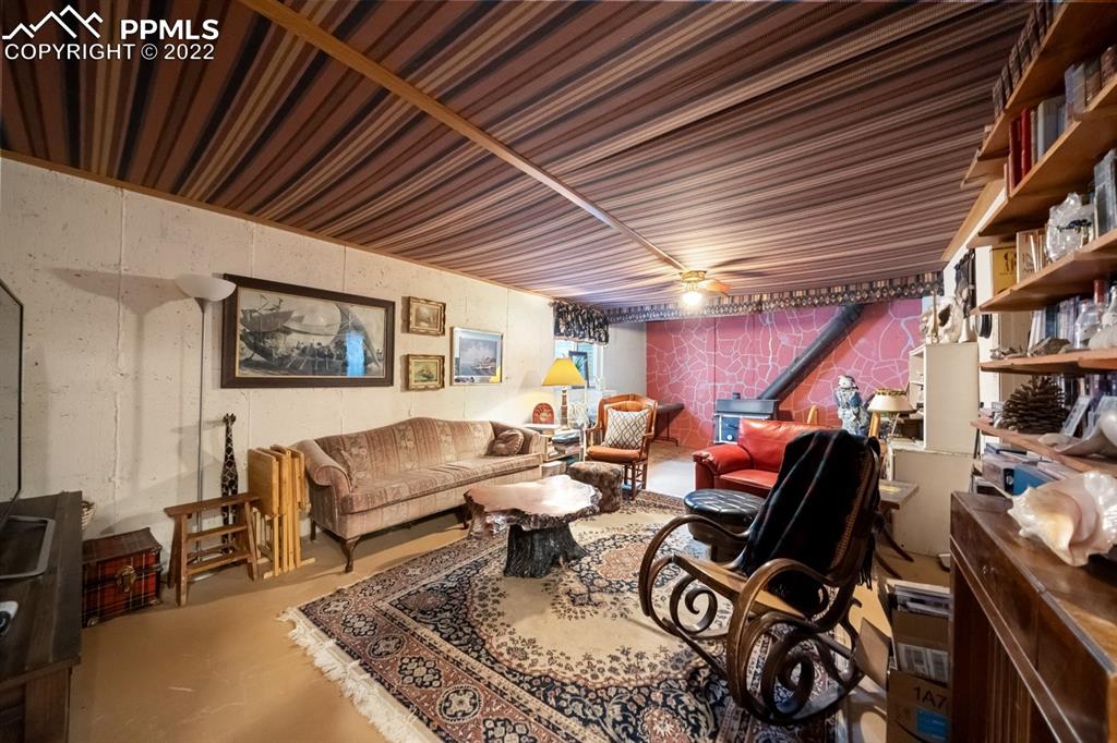 9180 McClelland Road Calhan, CO 80808 - Photo 25 of 31 a living room with furniture a rug and a bookshelf