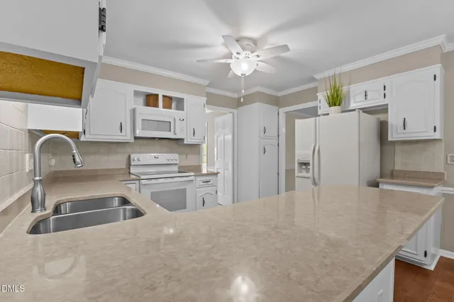 a kitchen with white cabinets and white appliances