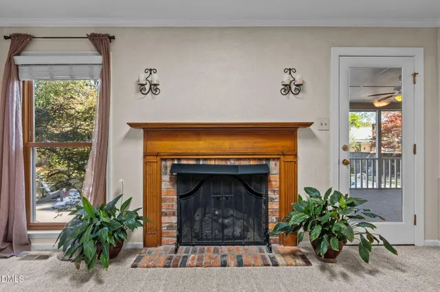 a view of an empty room with a fireplace and a window