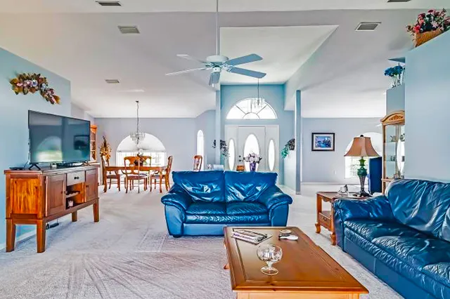 a living room with furniture kitchen view and a wooden floor
