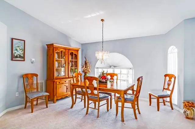 a dining room table chairs and a chandelier