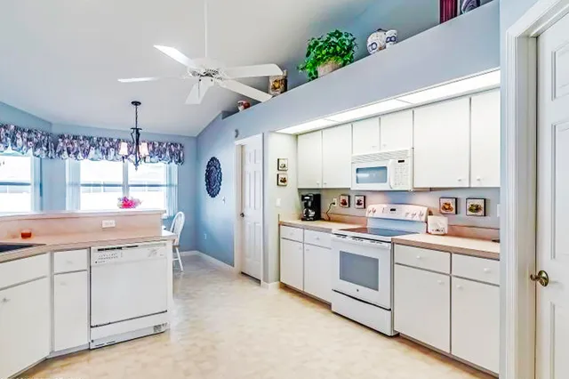 a kitchen with white cabinets and white appliances