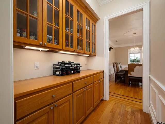 a kitchen with stainless steel appliances granite countertop a coffee maker a sink and white cabinets