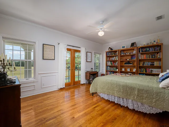 a bedroom with a bed and a bookshelf with wooden floor
