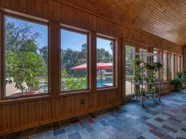 a view of a porch with furniture and floor to ceiling window
