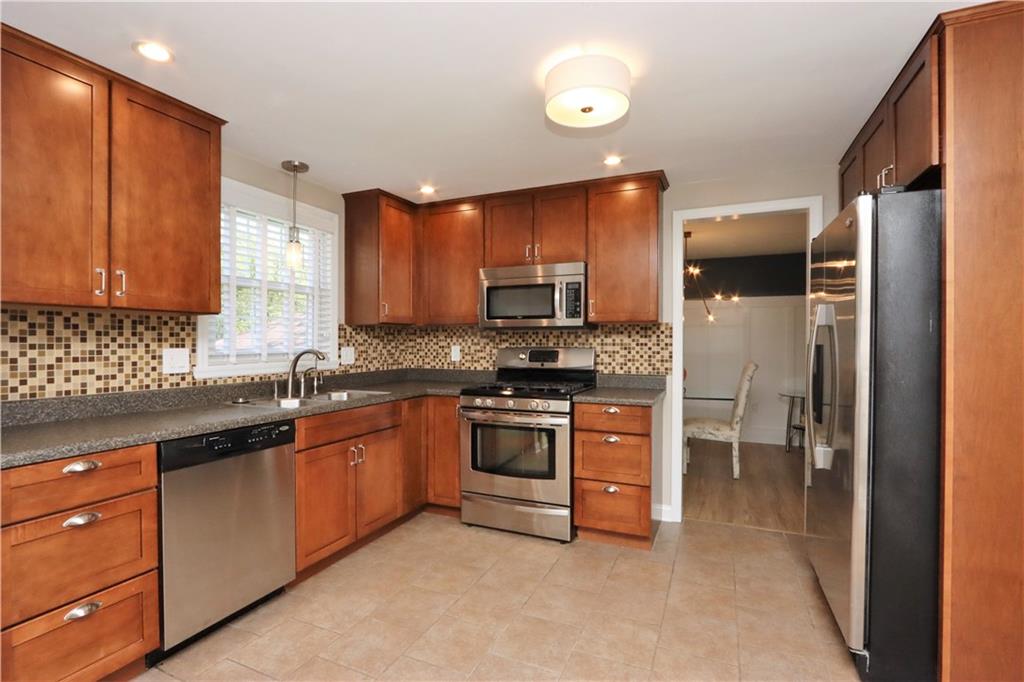 169 Mary Reed Road Baden, PA 15005 - Photo 6 of 24 a kitchen with stainless steel appliances granite countertop wooden cabinets a stove top oven a sink and dishwasher