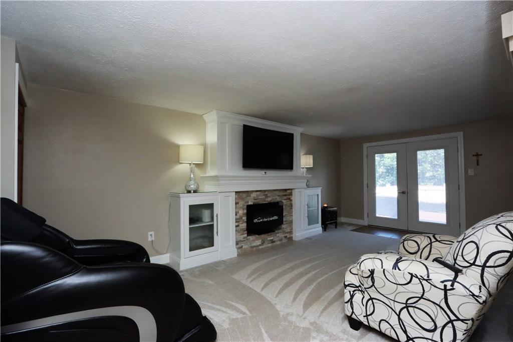169 Mary Reed Road Baden, PA 15005 - Photo 10 of 24 a living room with furniture a fireplace and a flat screen tv