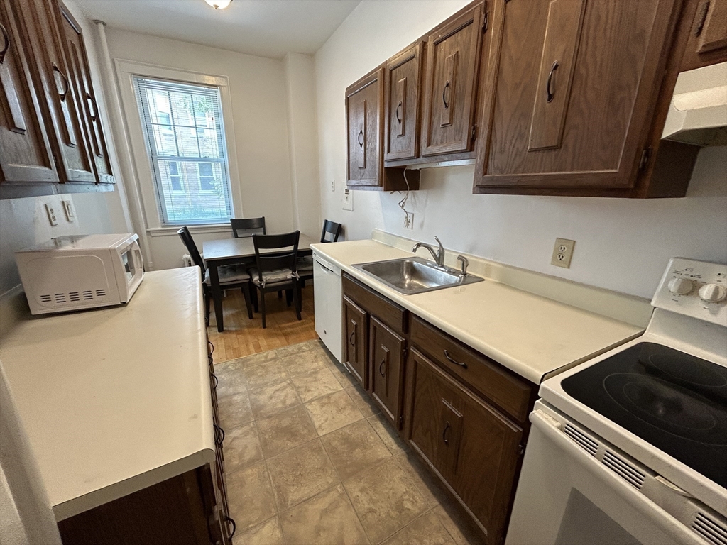 48 Strathmore Road, Unit 4 Boston, MA 02135 - Photo 6 of 10 a kitchen with a stove sink and cabinets