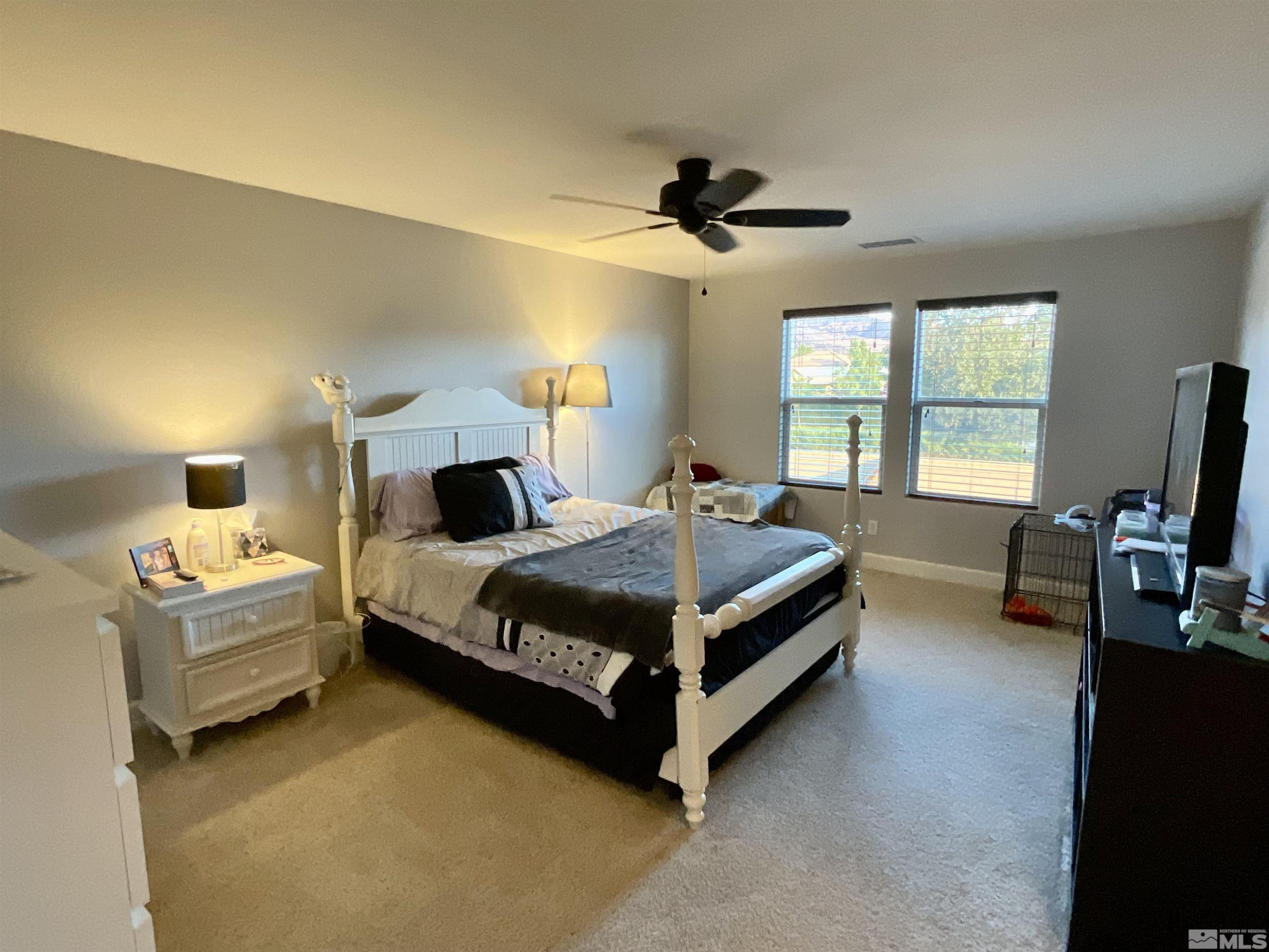 11640 Cervino Drive Reno, NV 89521 - Photo 14 of 26 a bedroom with a bed a chandelier and a couch