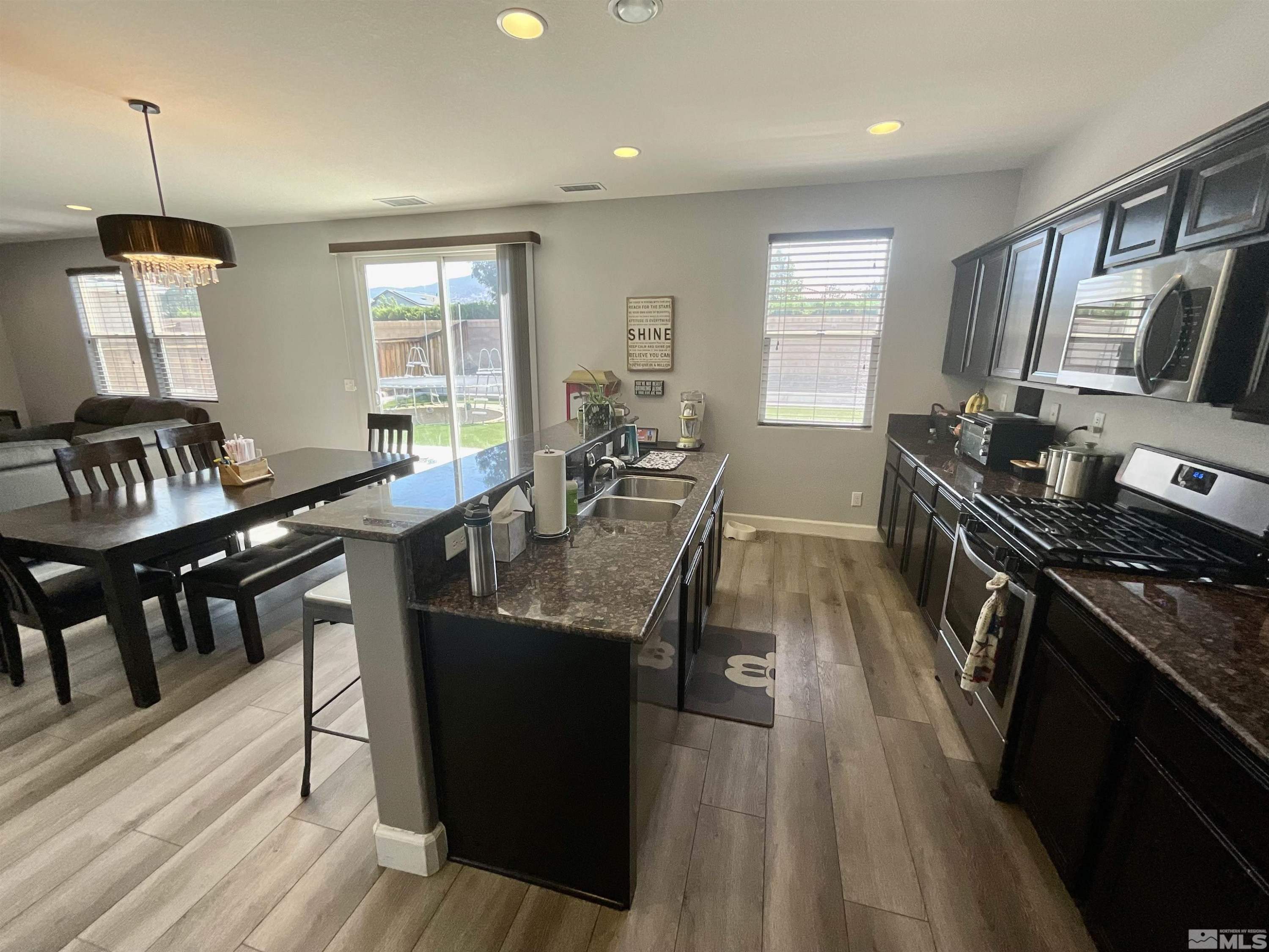 11640 Cervino Drive Reno, NV 89521 - Photo 9 of 26 a kitchen with granite countertop a sink stove top oven and cabinets