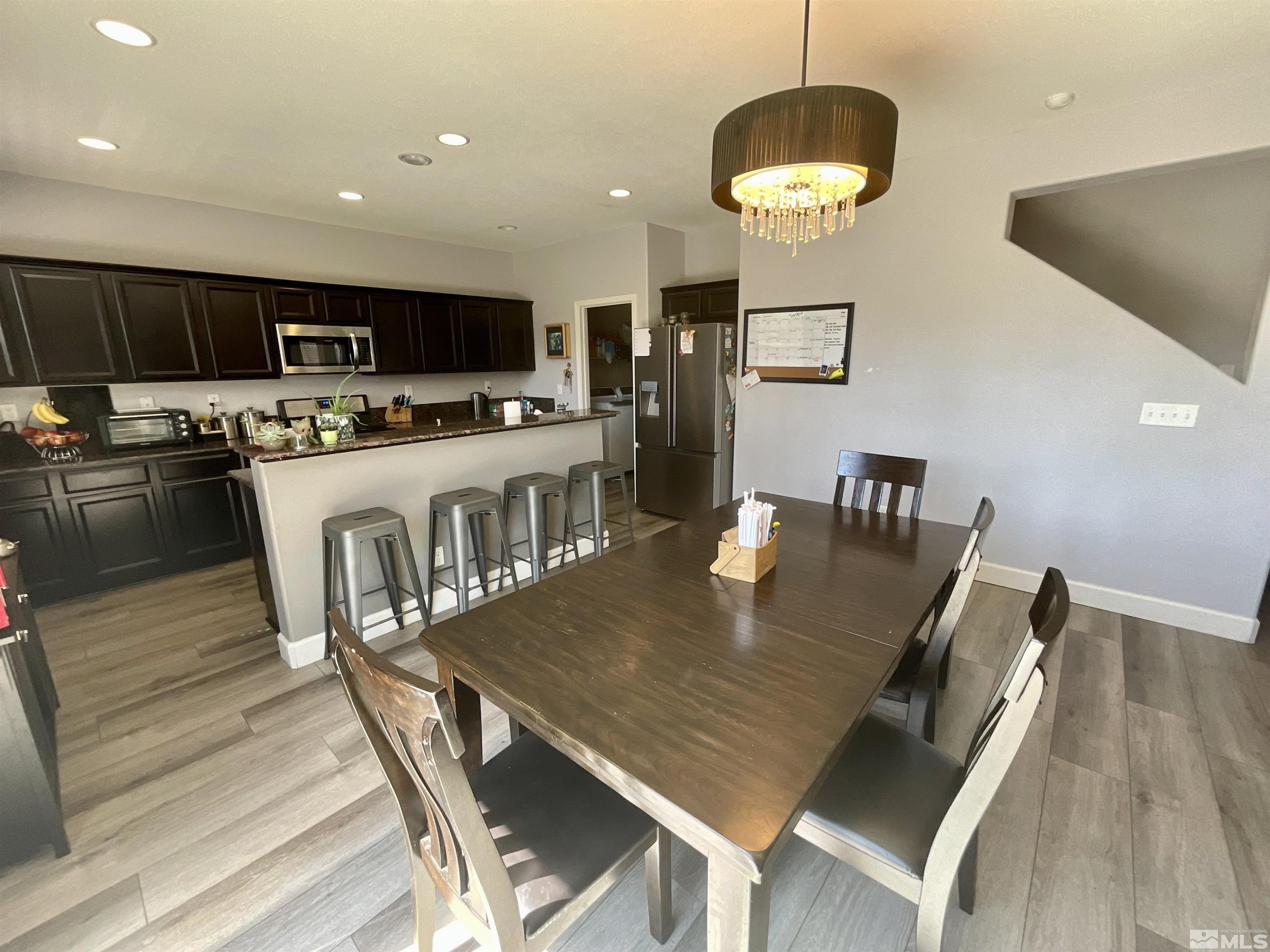 11640 Cervino Drive Reno, NV 89521 - Photo 10 of 26 a kitchen with stainless steel appliances granite countertop a stove a refrigerator a kitchen island a dining table and chairs