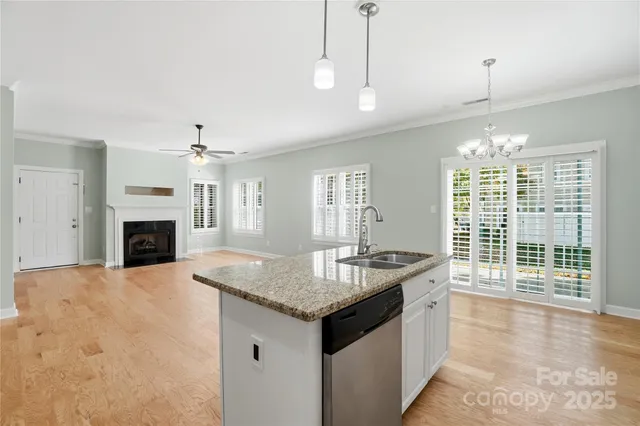 a kitchen with granite countertop a sink a counter top space and living room view