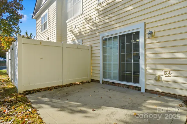 a view of a house with a door and wooden fence