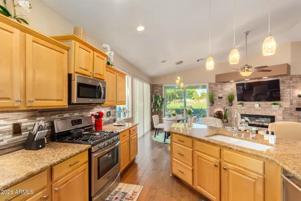 a kitchen with stainless steel appliances granite countertop a sink a stove and a microwave