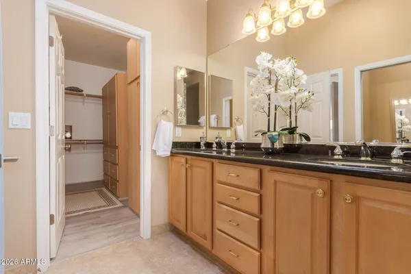 a spacious bathroom with a granite countertop sink a mirror and a shower