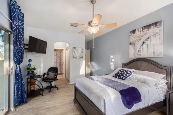 a bedroom with a bed a chandelier and a flat tv screen