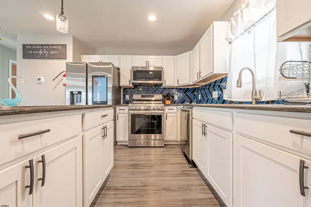 a kitchen with stainless steel appliances granite countertop a sink and cabinets