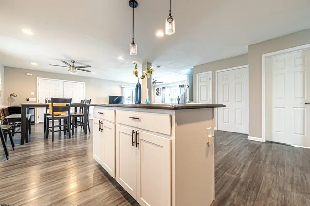 a kitchen with stainless steel appliances kitchen island granite countertop a table chairs and a refrigerator