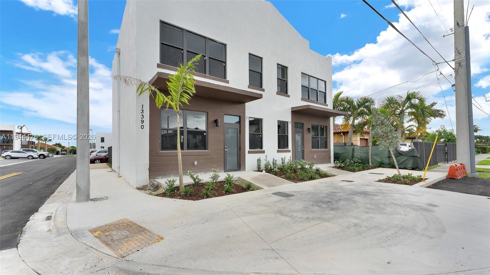 13390 Southwest 251st Terrace, Unit 1 Homestead, FL 33032 - Photo 1 of 22 a view of a brick building next to a yard