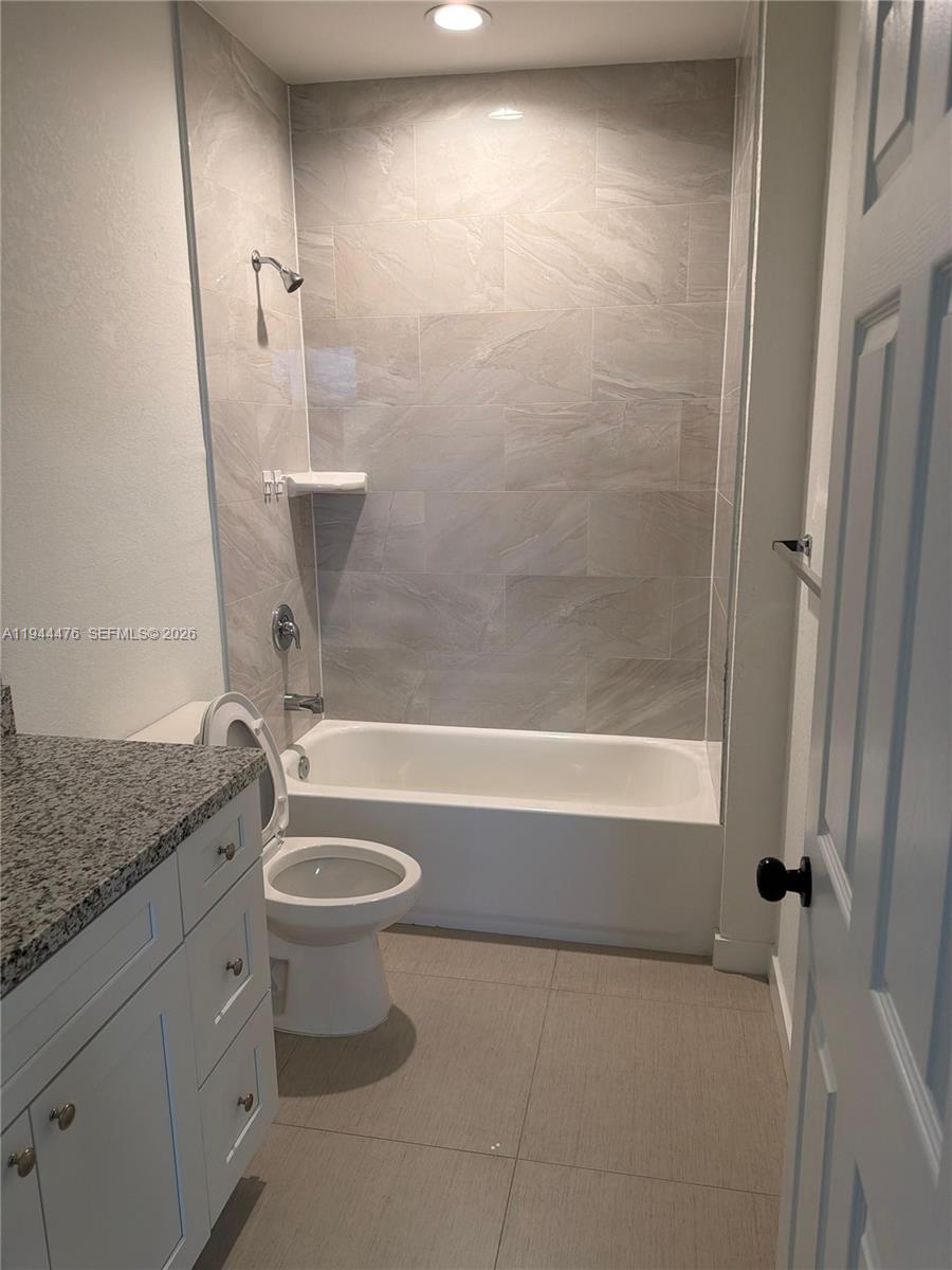 13390 Southwest 251st Terrace, Unit 1 Homestead, FL 33032 - Photo 12 of 22 a bathroom with a granite countertop sink a toilet and bathtub
