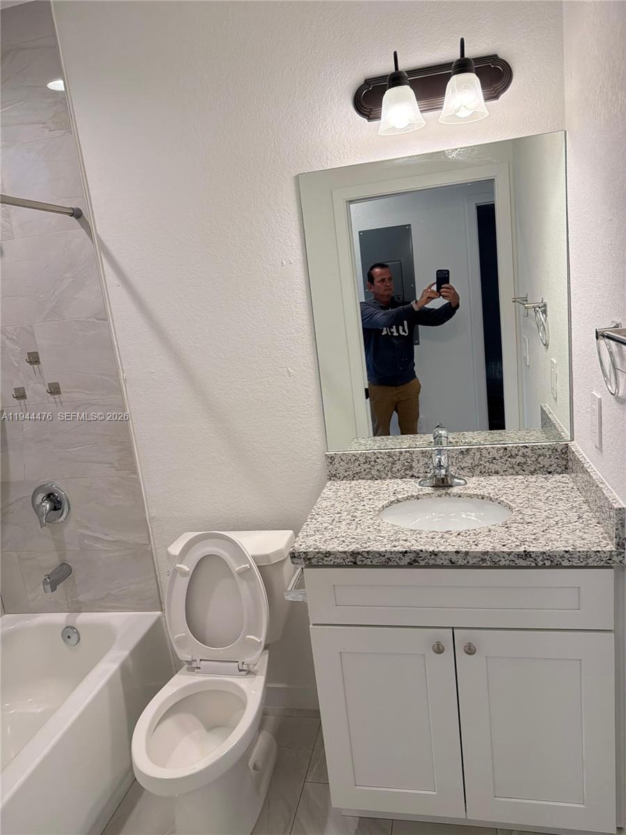 13390 Southwest 251st Terrace, Unit 1 Homestead, FL 33032 - Photo 15 of 22 a bathroom with a granite countertop sink toilet and mirror