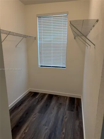 a view of a room with wooden floor and a window
