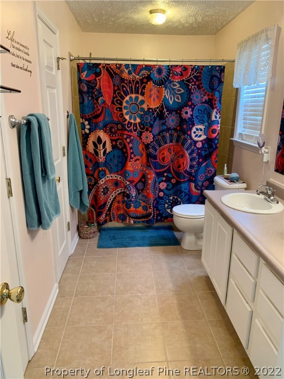 4481 Virsalli Loop Hope Mills, NC 28348 - Photo 15 of 24 a bathroom with a toilet and a shower curtain