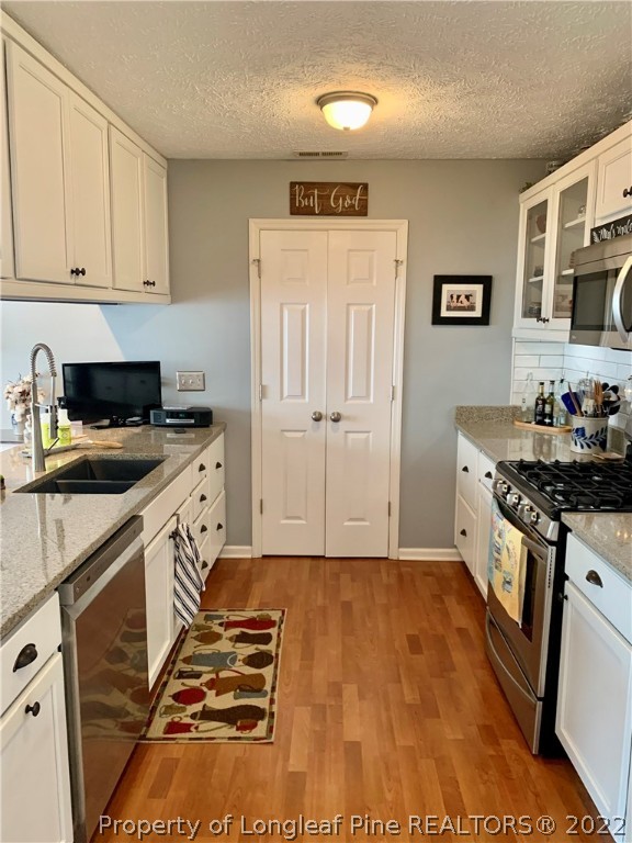 4481 Virsalli Loop Hope Mills, NC 28348 - Photo 2 of 24 a kitchen with granite countertop a stove and a sink